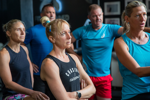 Group of people training in gym listening to the instructor