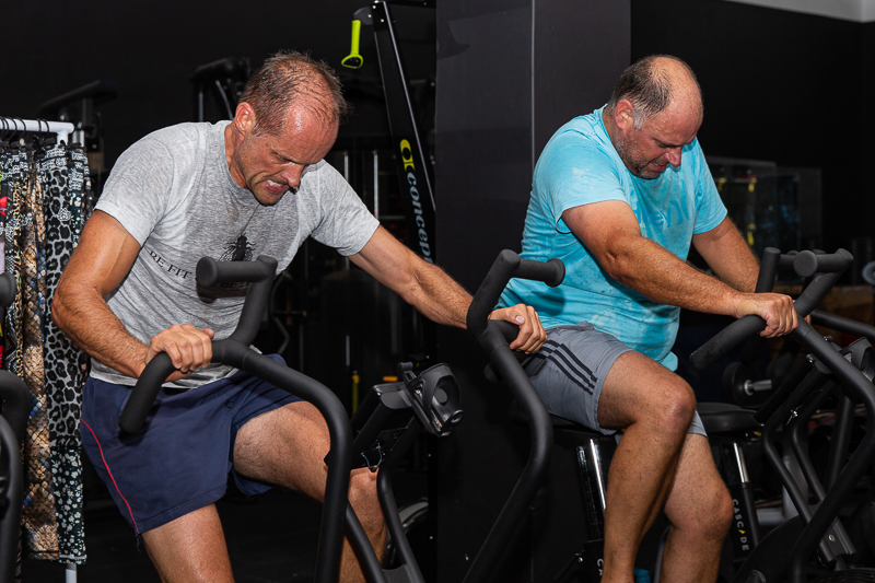 Two guys on gym bikes